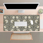 Desk setup with a floral patterned William Morris desk mat, keyboard, and computer monitor.