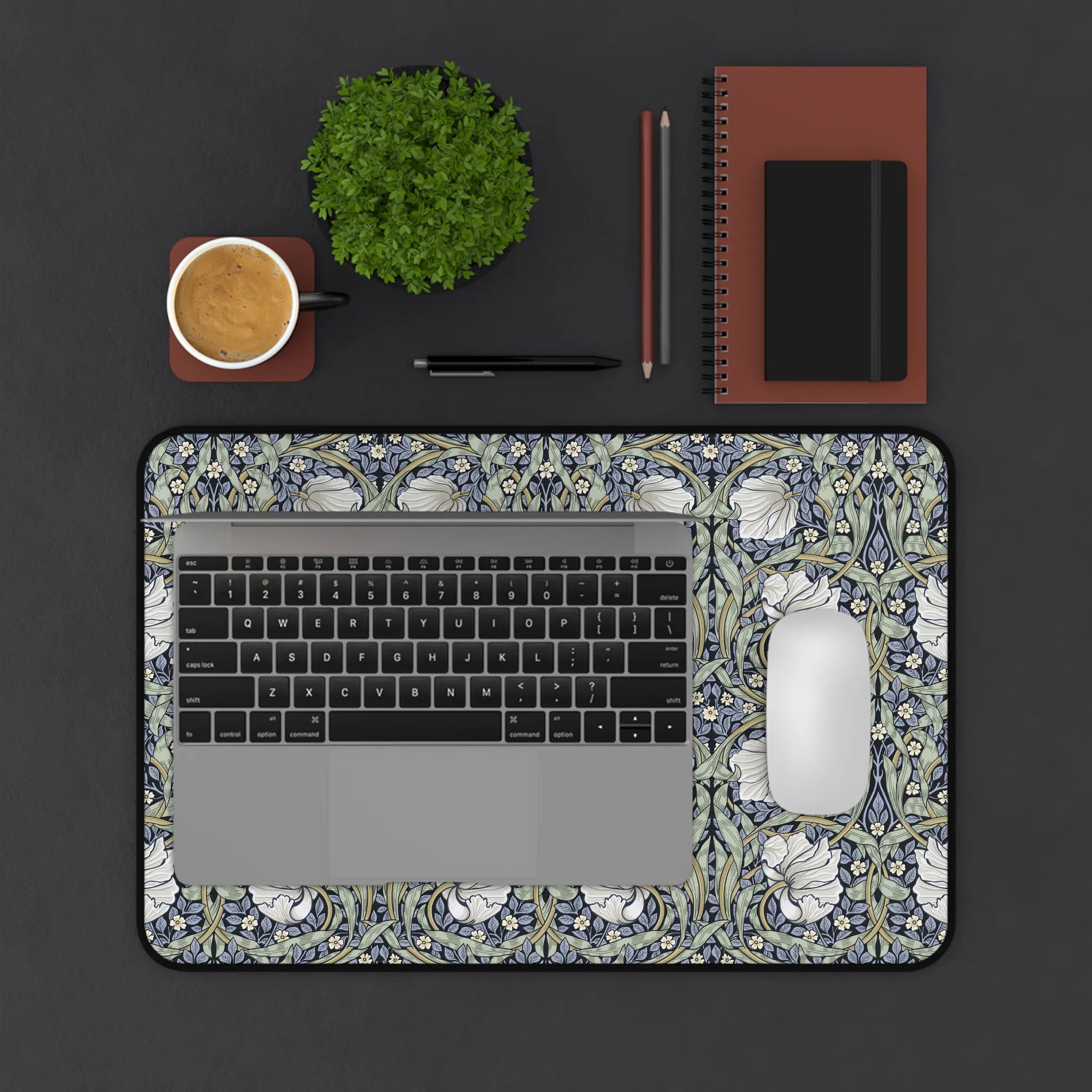 Decorative William Morris laptop desk mat with floral Pimpernel pattern on a dark surface with office items.