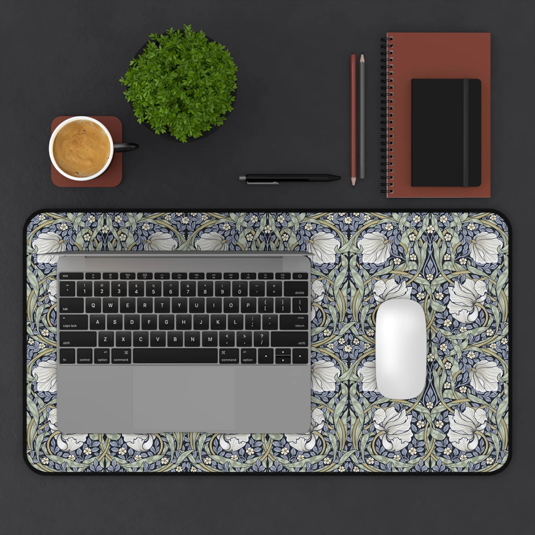 Decorative William Morris desk mat setup with a laptop, mouse, and stationery on a floral-patterned desk pad.