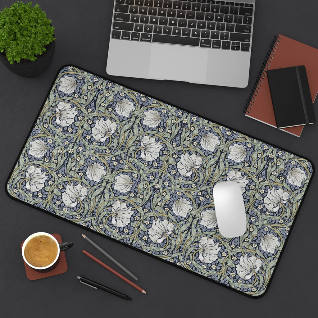 Floral patterned William Morris desk mat on a desk with laptop, coffee, and stationery items.