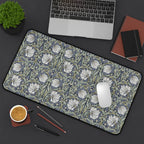 Floral patterned William Morris desk mat on a desk with laptop, coffee, and stationery items.
