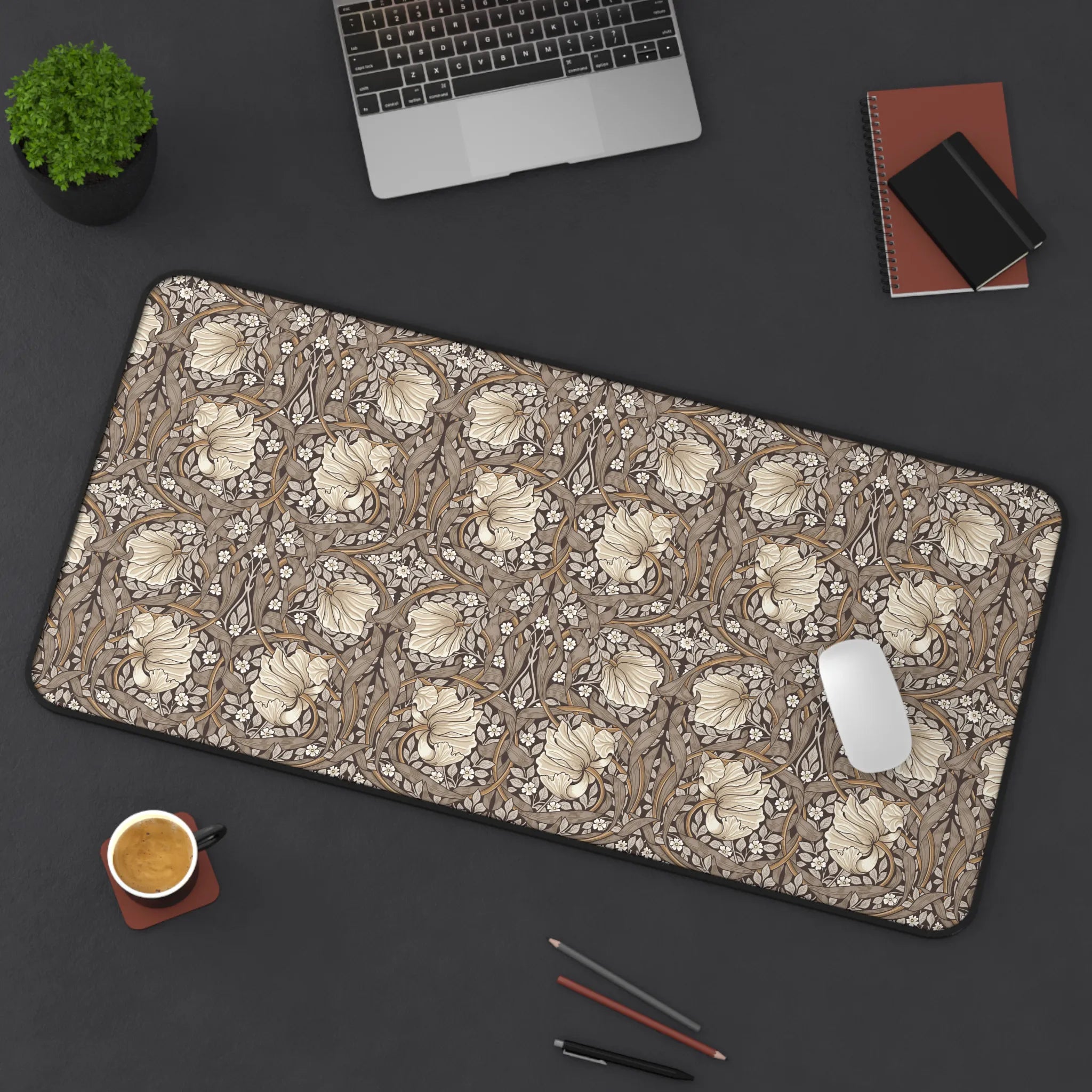 Large William Morris desk mat mousepad with Pimpernel floral pattern on a dark surface with office items.