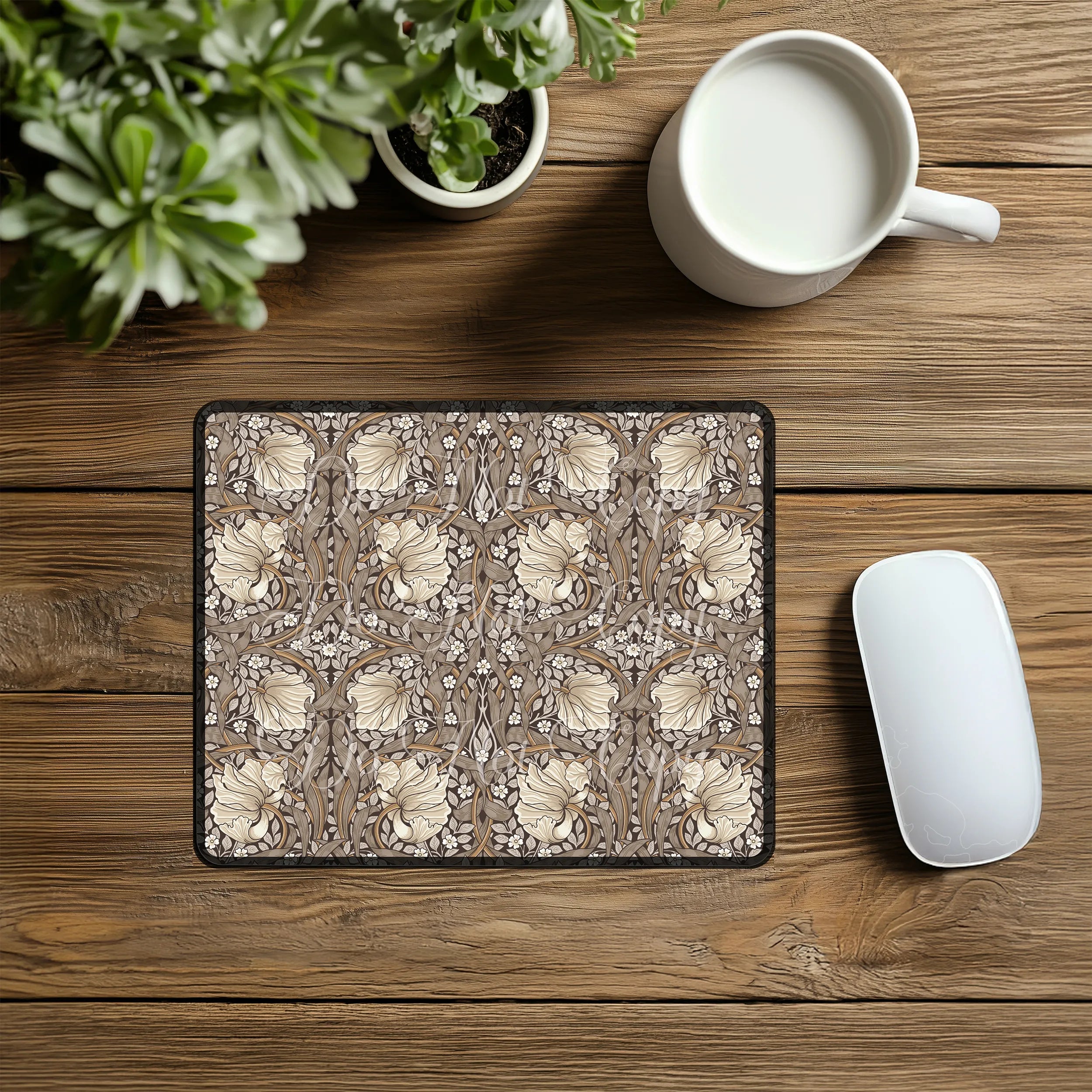 Decorative William Morris mouse pad with floral pattern on a wooden desk with a mug and plant.