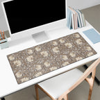 Desk setup with a large floral William Morris desk mat pad, computer monitor, and books.