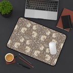 William Morris Pimpernel desk mat in rich cocoa brown and beige, with a mouse, laptop, coffee, and stationery on a dark surface.