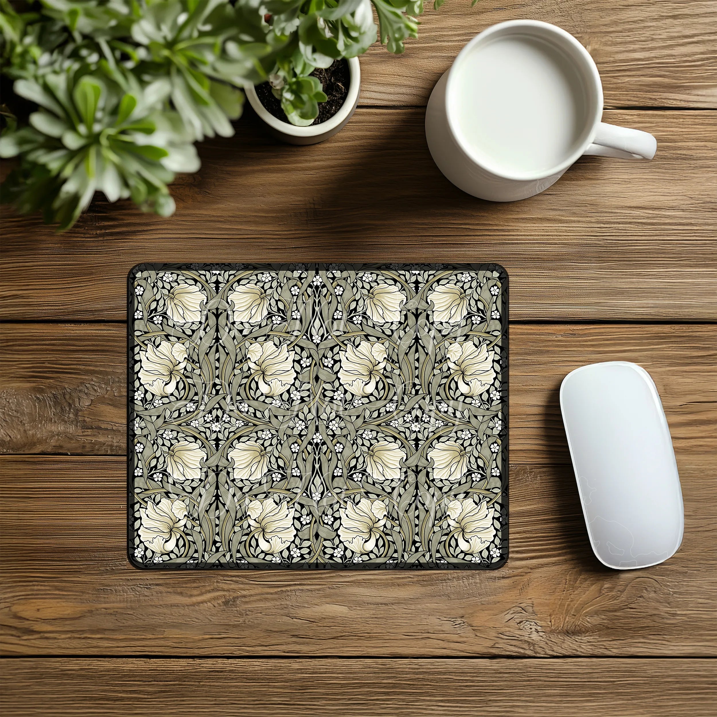Decorative William Morris Pimpernel mouse pad with floral pattern on a wooden desk with a mug and plant.