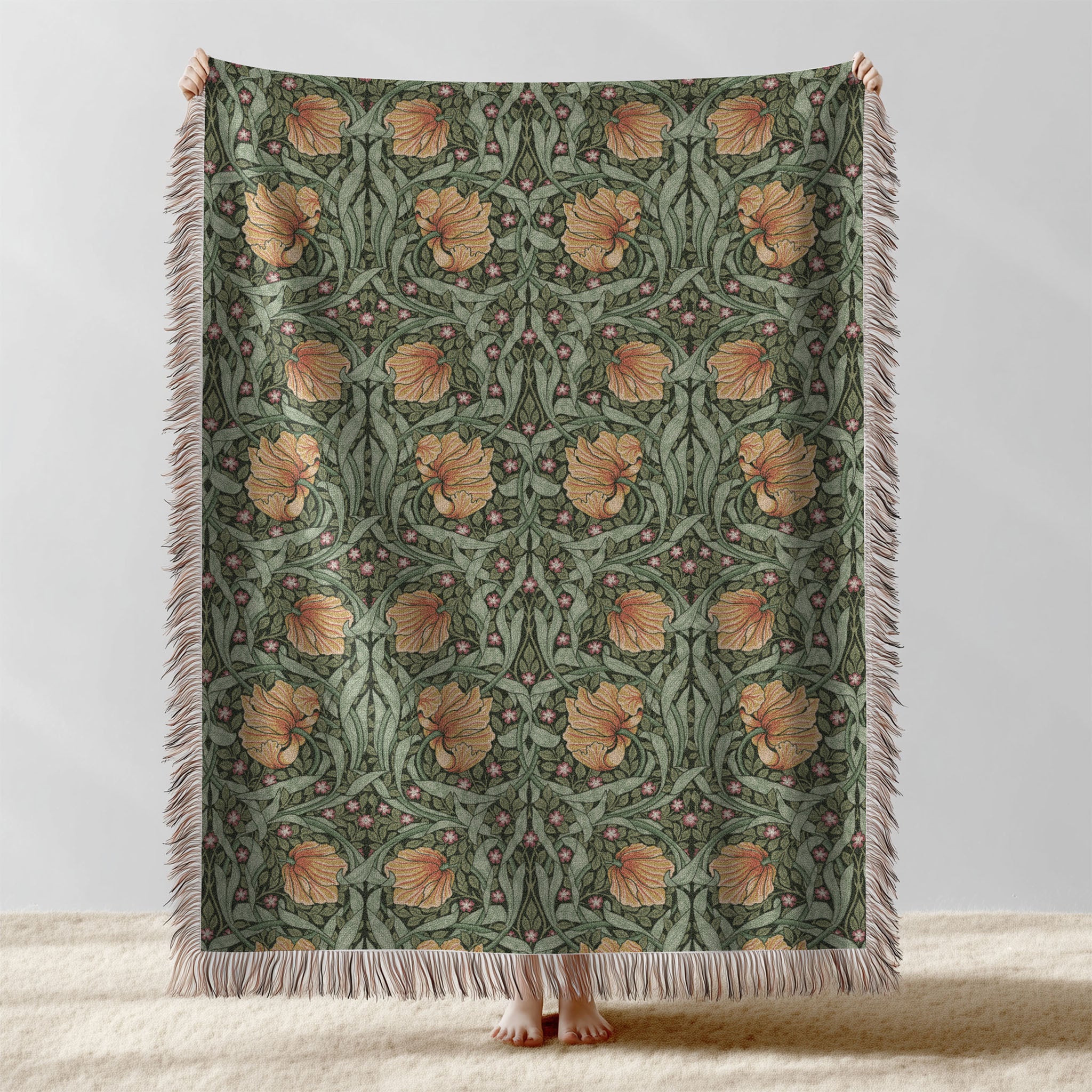 William Morris Pimpernel woven blanket displayed full length with fringe, botanical Arts and Crafts design in sage green and copper