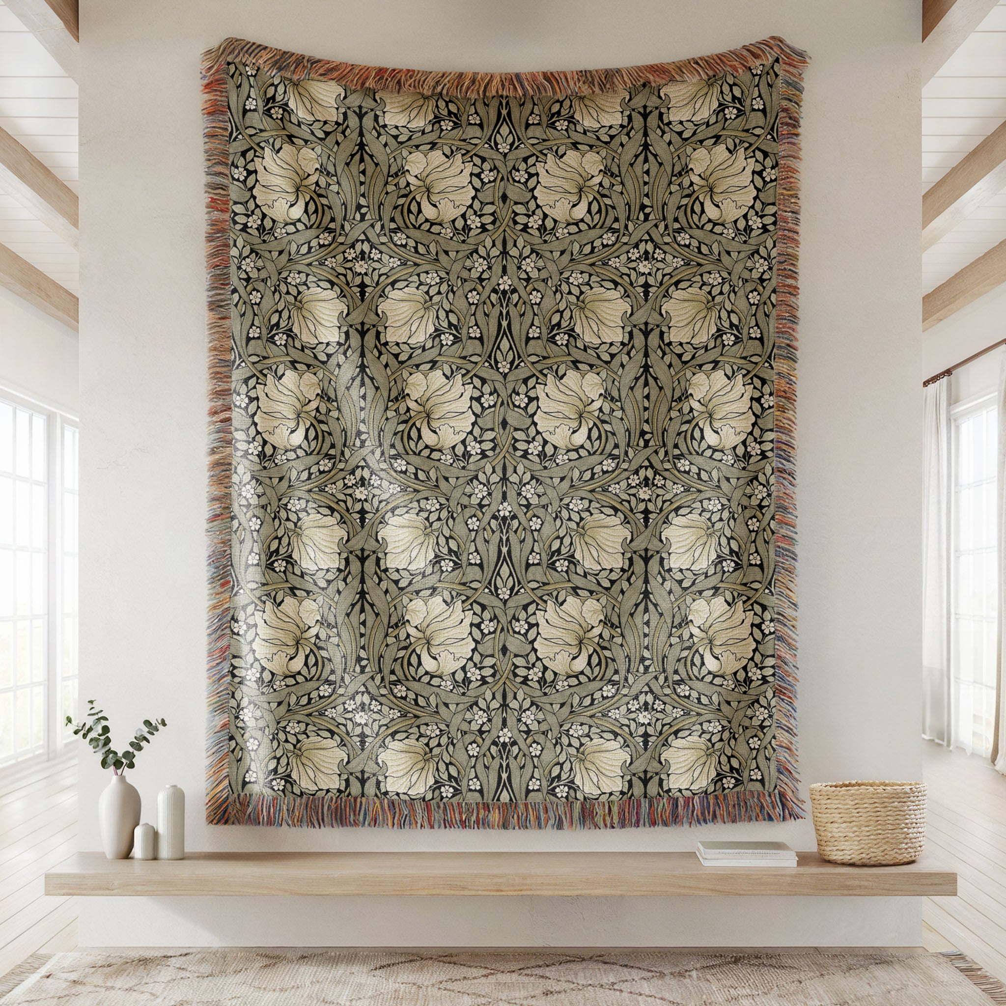 William Morris Pimpernel woven blanket hanging display, intricate floral pattern showcased as statement textile in sage green and cream on ebony black