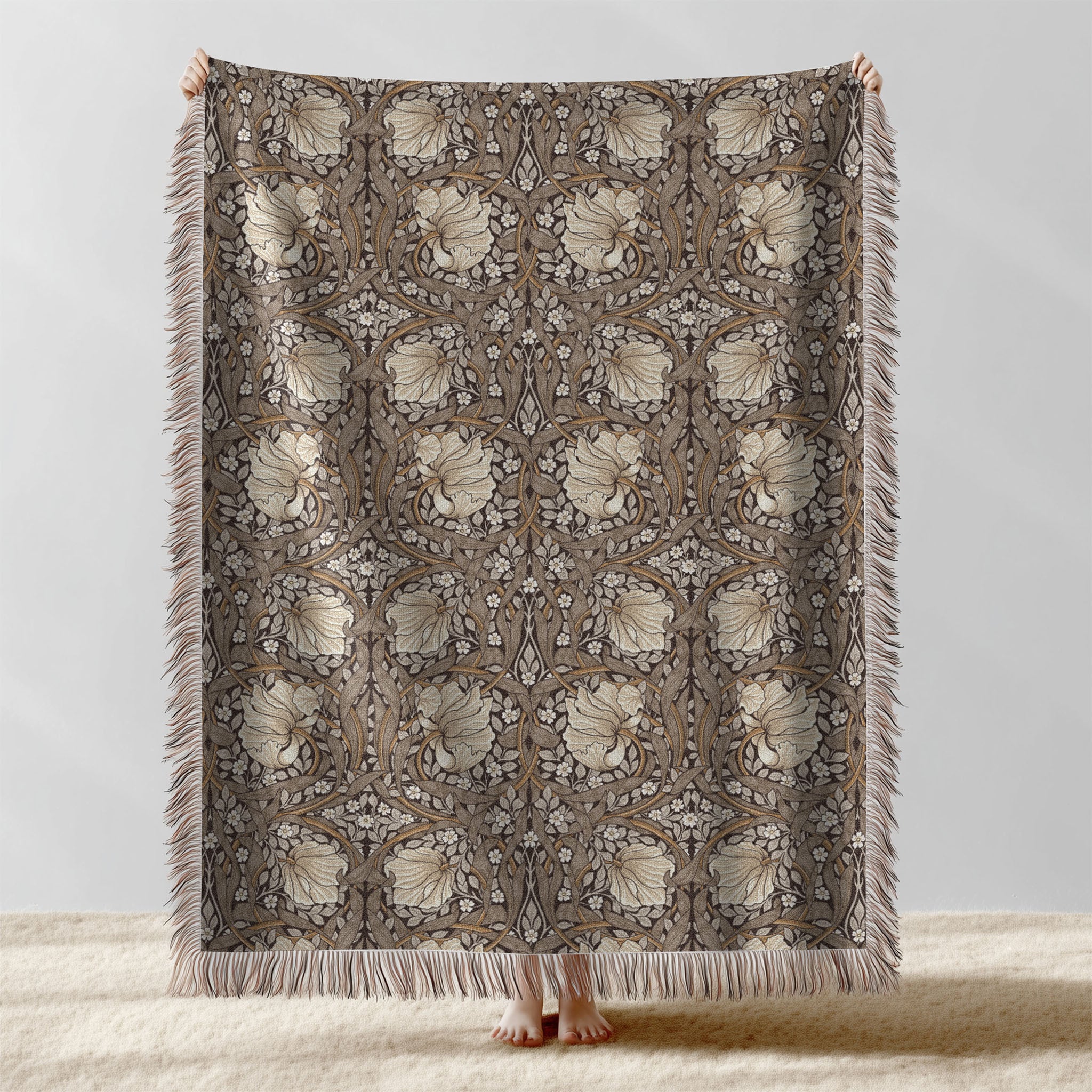 William Morris Pimpernel woven blanket displayed full length with fringe, botanical Arts and Crafts design in neutral cocoa brown tones