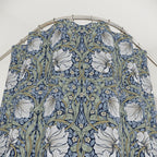 William Morris shower curtain in blue and sage green Pimpernel pattern on a metal hoop against a white background