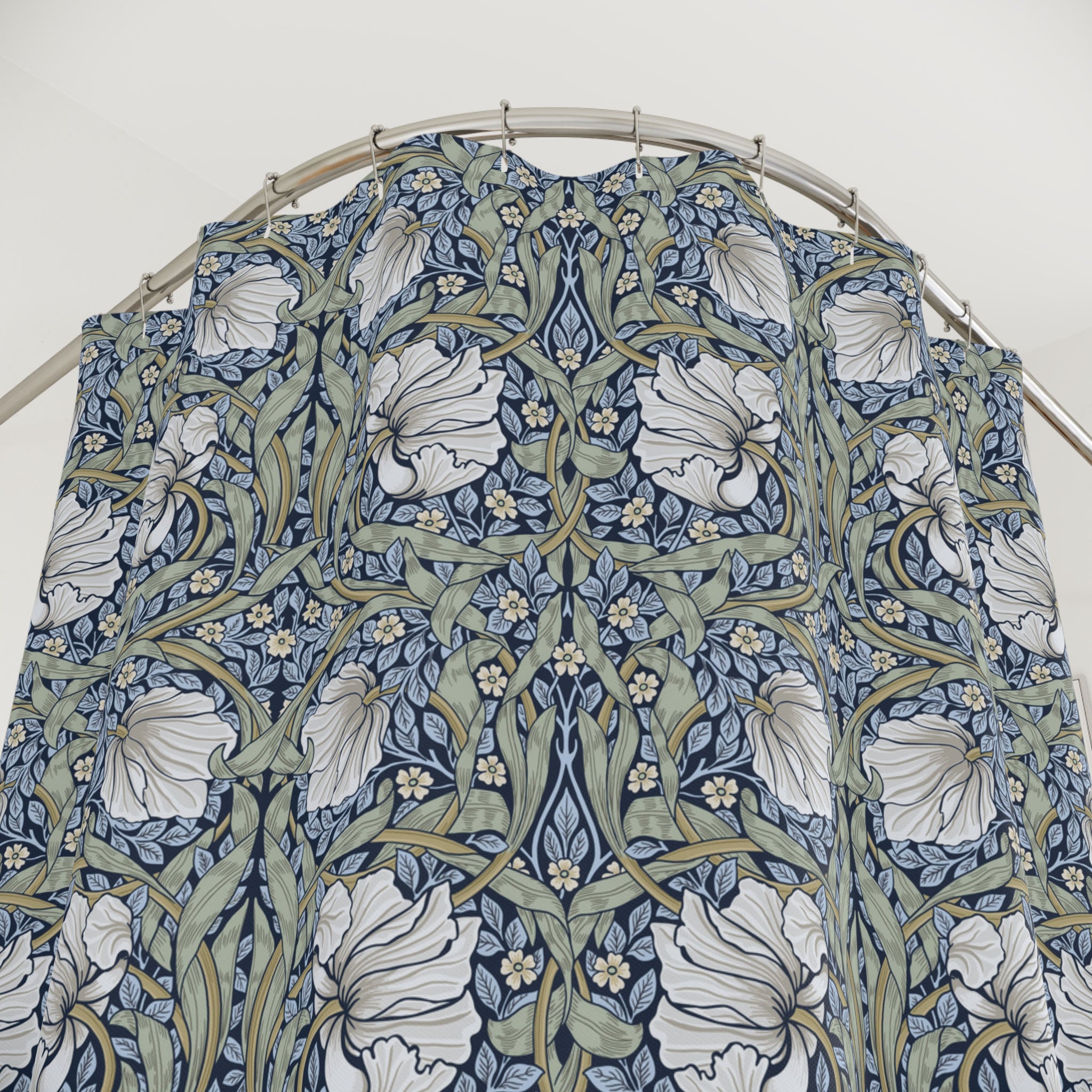 William Morris shower curtain in blue and sage green Pimpernel pattern on a metal hoop against a white background