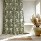 Bathroom with a William Morris Pimpernel shower curtain in Silver Sage green, white bathtub, and decorative vase with pampas grass.