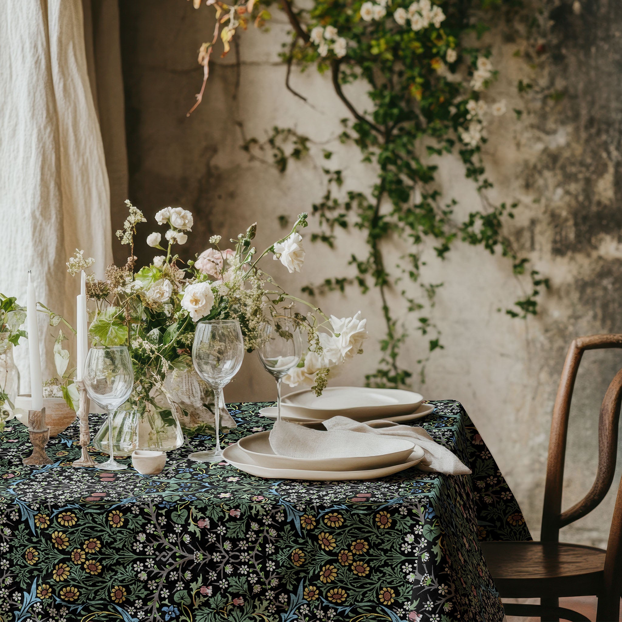 William Morris Blackthorn tablecloth in classic black with intricate vines and floral motifs, styled for cottagecore tablescapes and English country dining rooms.