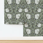 William Morris Pimpernel wallpaper in Dreamy Sage shown partially installed on a wall.