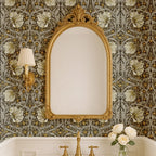 Bathroom interior with ornate mirror against William Morris Pimpernel wallpaper, showcasing classic botanical Arts and Crafts wallpaper in an elegant heritage style space.