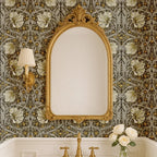 Bathroom with ornate mirror against William Morris Pimpernel wallpaper in Heritage Greige and Ochre.