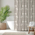 Bathroom with a floral-patterned William Morris Pimpernel shower curtain, white bathtub, and wooden table with towels.