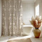 Bathroom with a William Morris shower curtain in soft beige Pimpernel pattern, freestanding bathtub, and decorative vase with pampas grass.