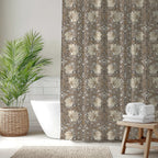Bathroom with a William Morris shower curtain in beige tones, white bathtub, and wooden stool with towels.
