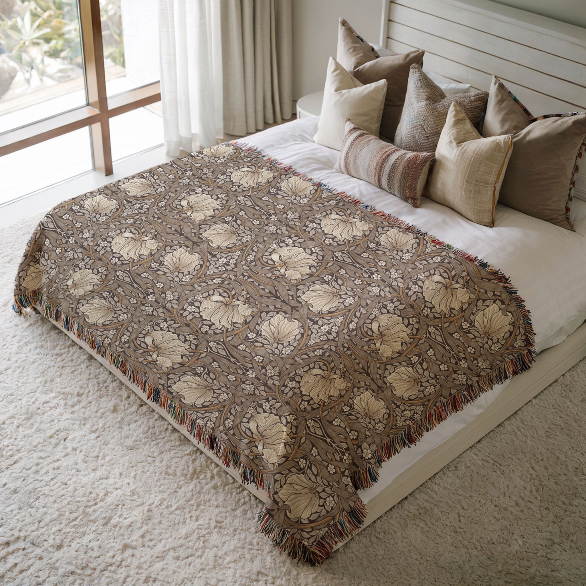 William Morris Pimpernel woven blanket styled on bed. Soft botanical throw in neutral brown and beige tones adding texture to cozy bedroom decor