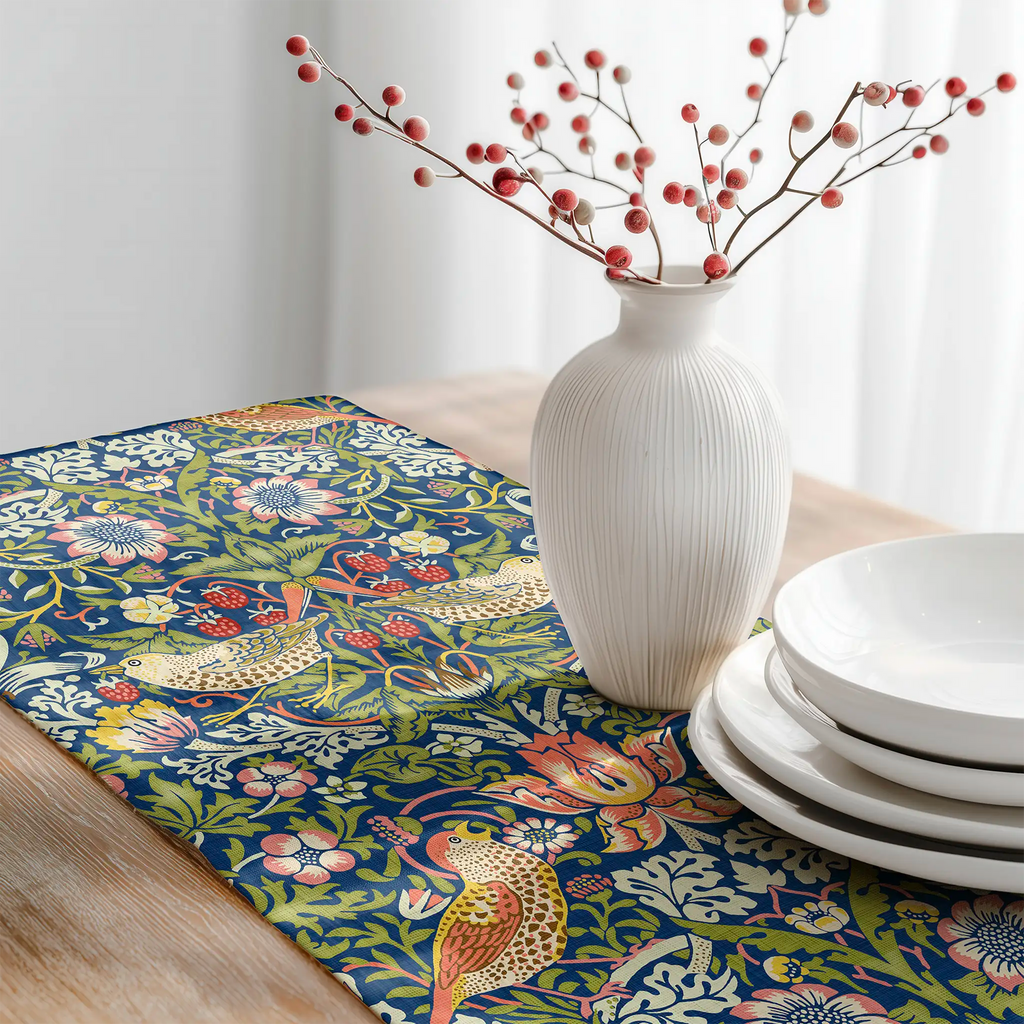 William Morris Strawberry Thief table runner featuring the iconic Arts and Crafts bird and botanical pattern, styled on a rustic wooden table for heritage revival and English country dining decor.