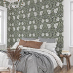 Bedroom styled with William Morris Pimpernel wallpaper in Dreamy Sage behind the bed.