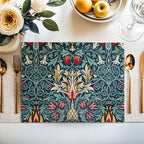 William Morris Snakeshead placemat in Teal & Garnet styled on a dining table with florals and a place setting.
