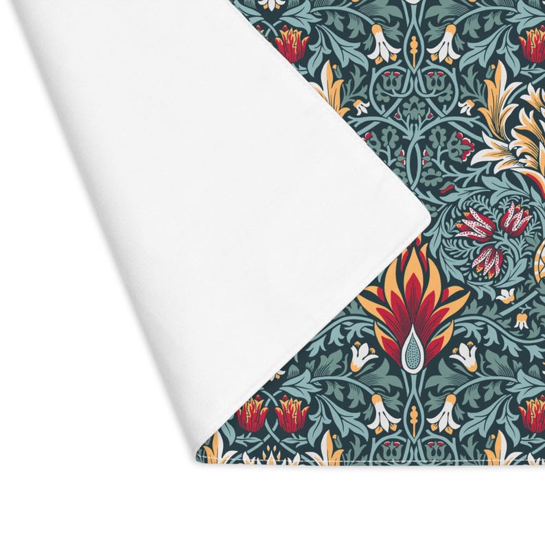 William Morris Snakeshead placemat in Teal & Garnet styled with floral accents on a table.